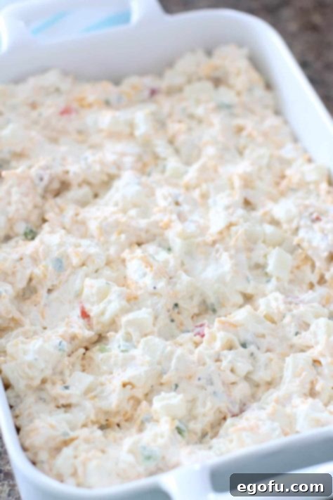 funeral potatoes mixture spread into a baking dish.
