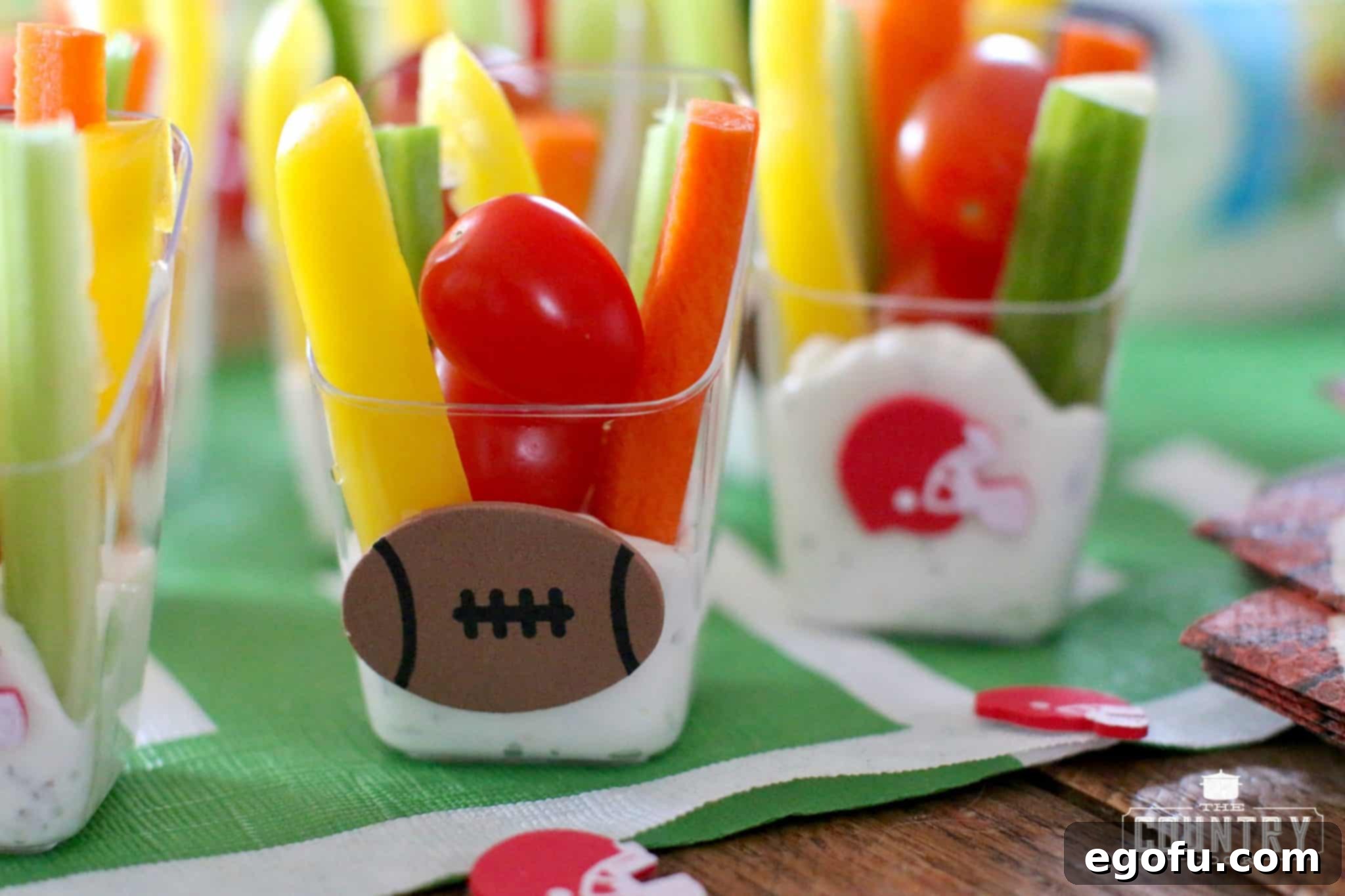 Decorated Veggie Dip Cups with football and helmet stickers, arranged for a themed party.