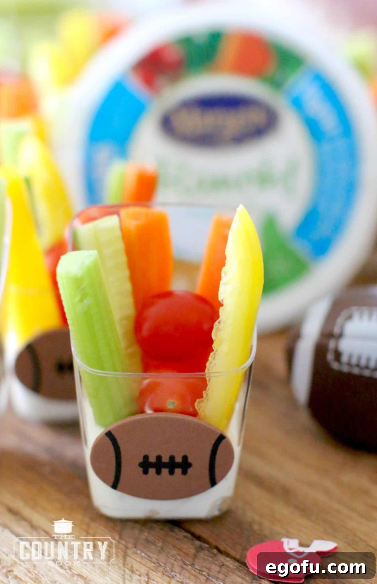 Close-up photo of a single veggie dip cup adorned with a football sticker.