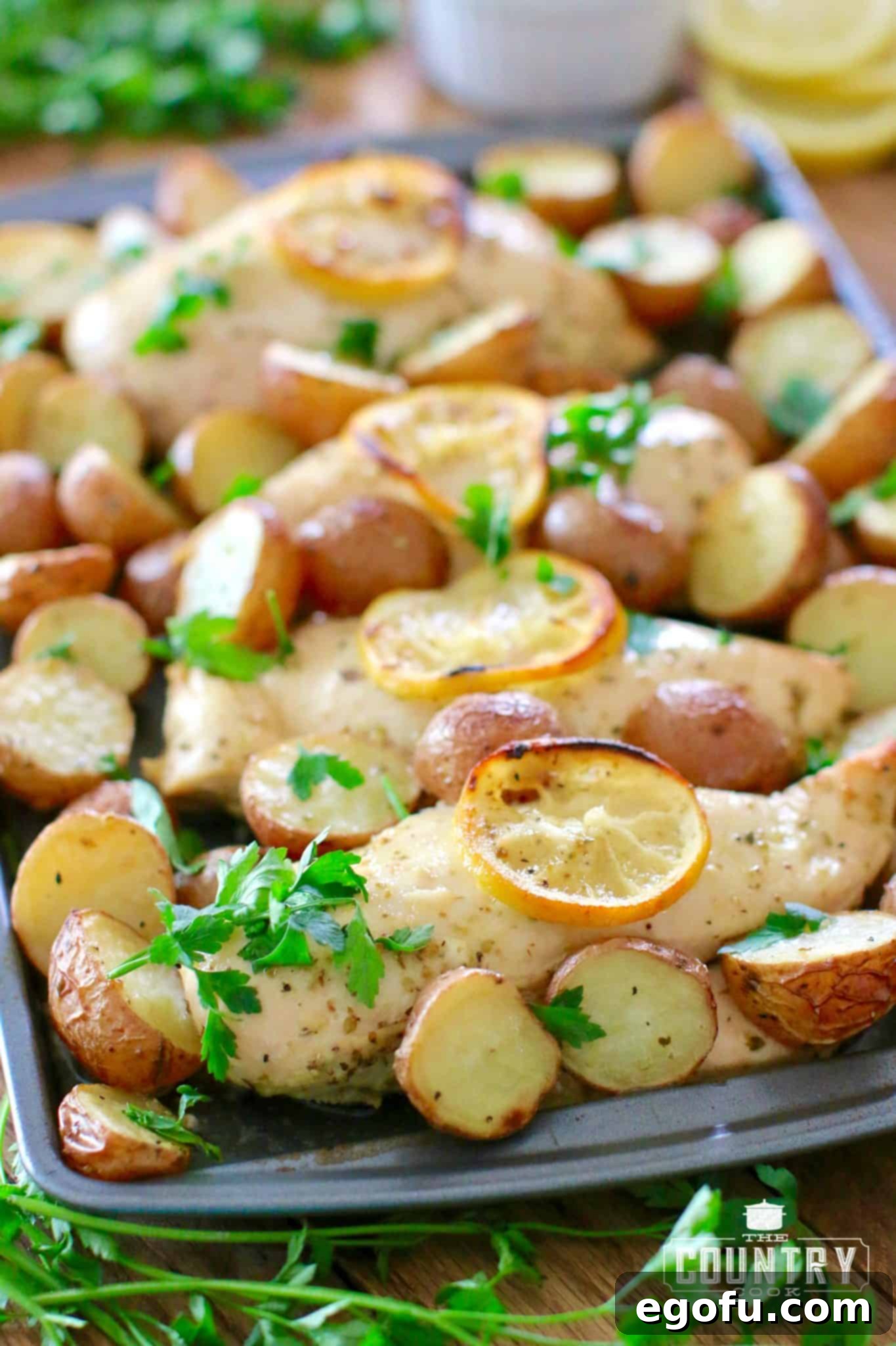 One Pan Greek Lemon Chicken and Potatoes shown fully cooked and on a baking sheet.