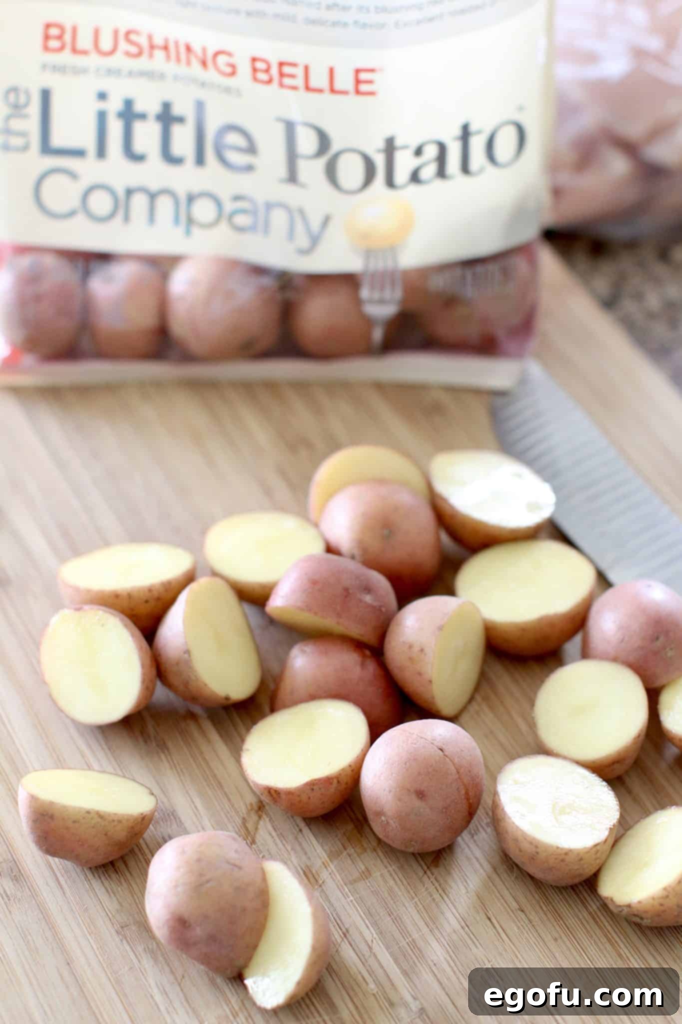 Sliced red baby potatoes on a cutting board.