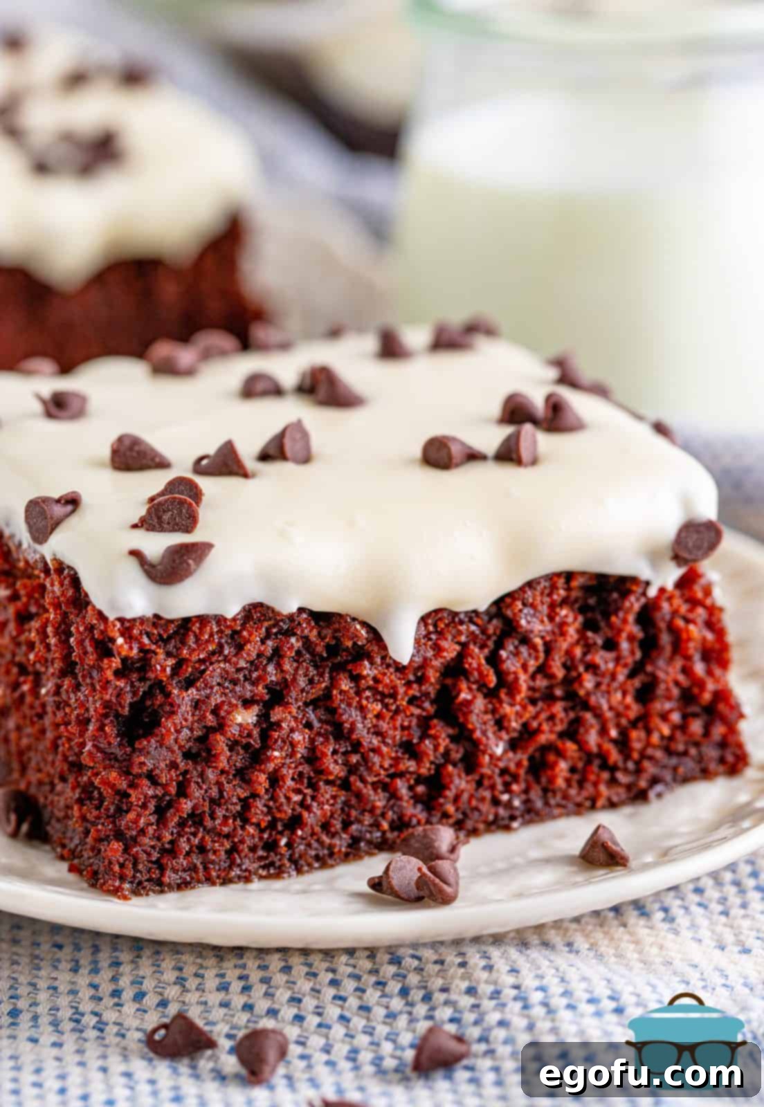 closeup side photo of a slice of chocolate cake with cream cheese frosting.