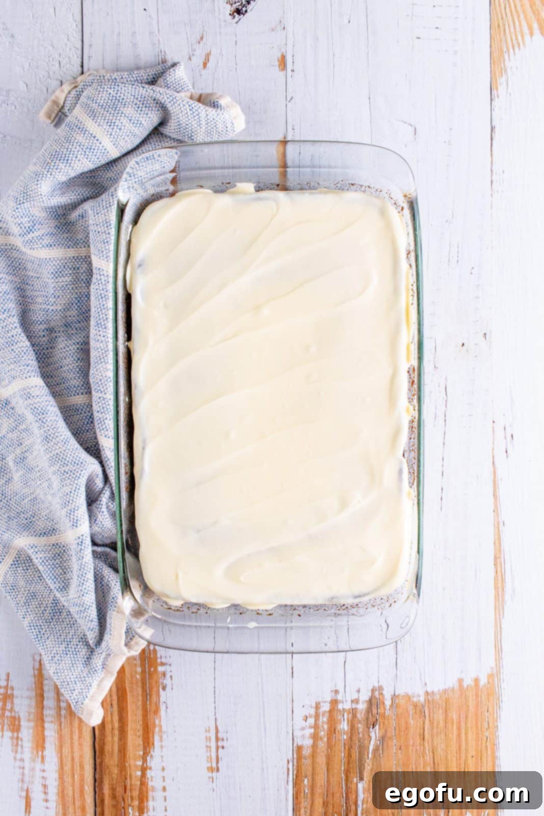 frosting added to the top of the chocolate cake.