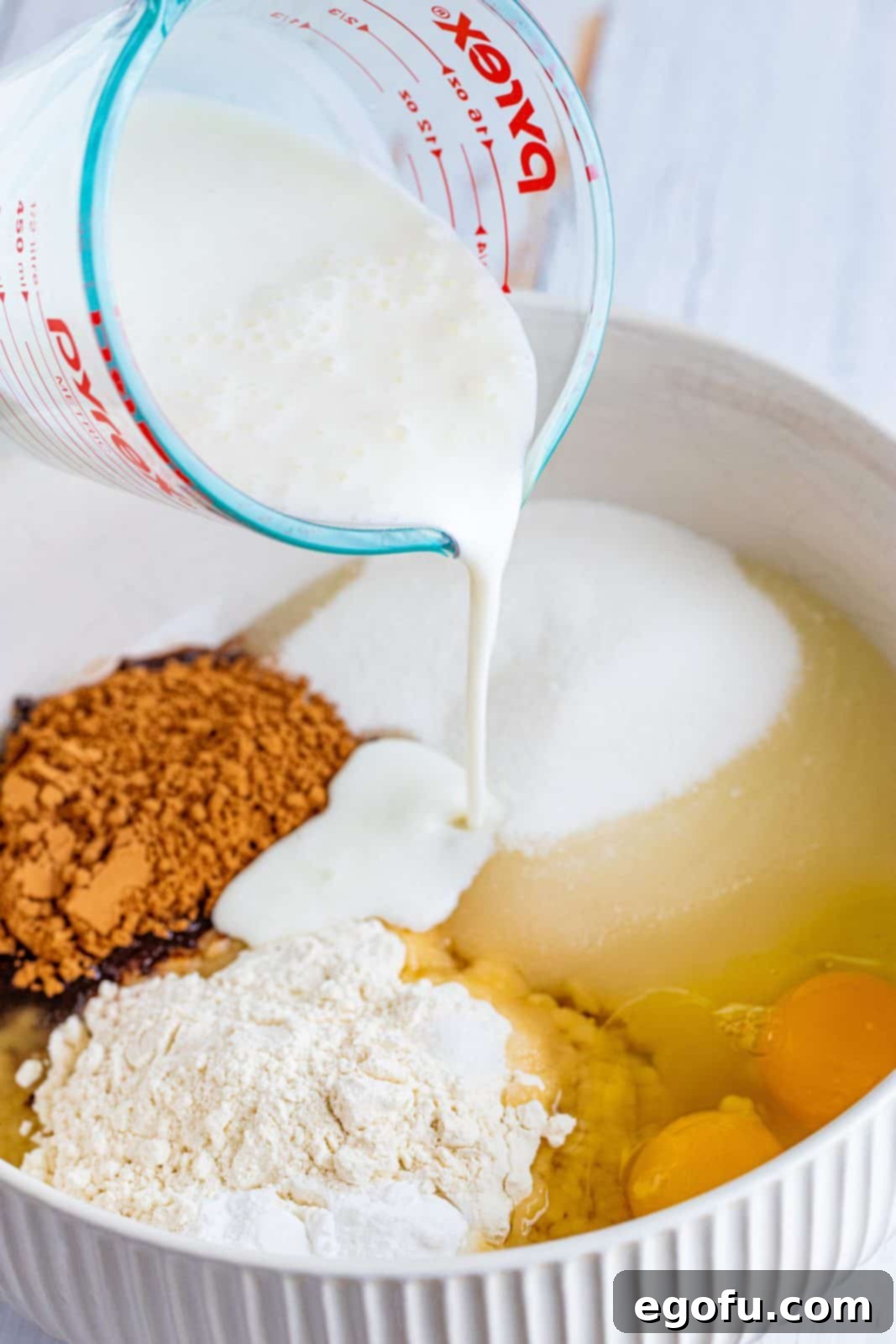 cake ingredients added to a large white bowl.