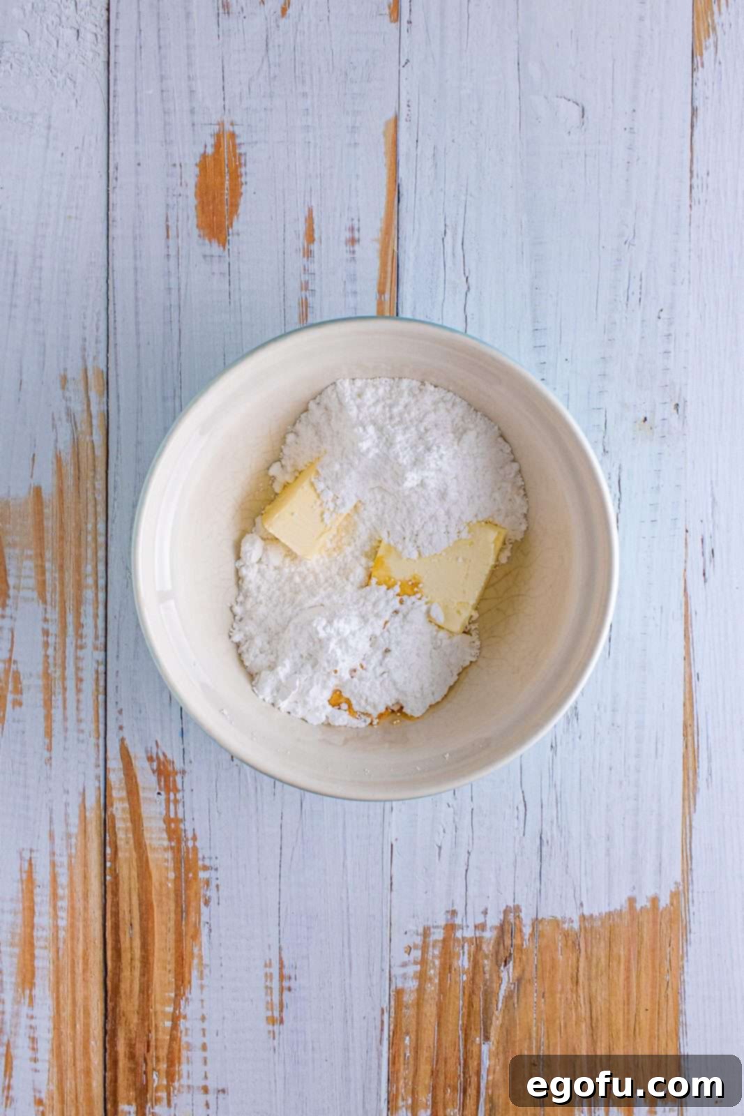 margarine, cream cheese and powdered sugar in a small white bowl