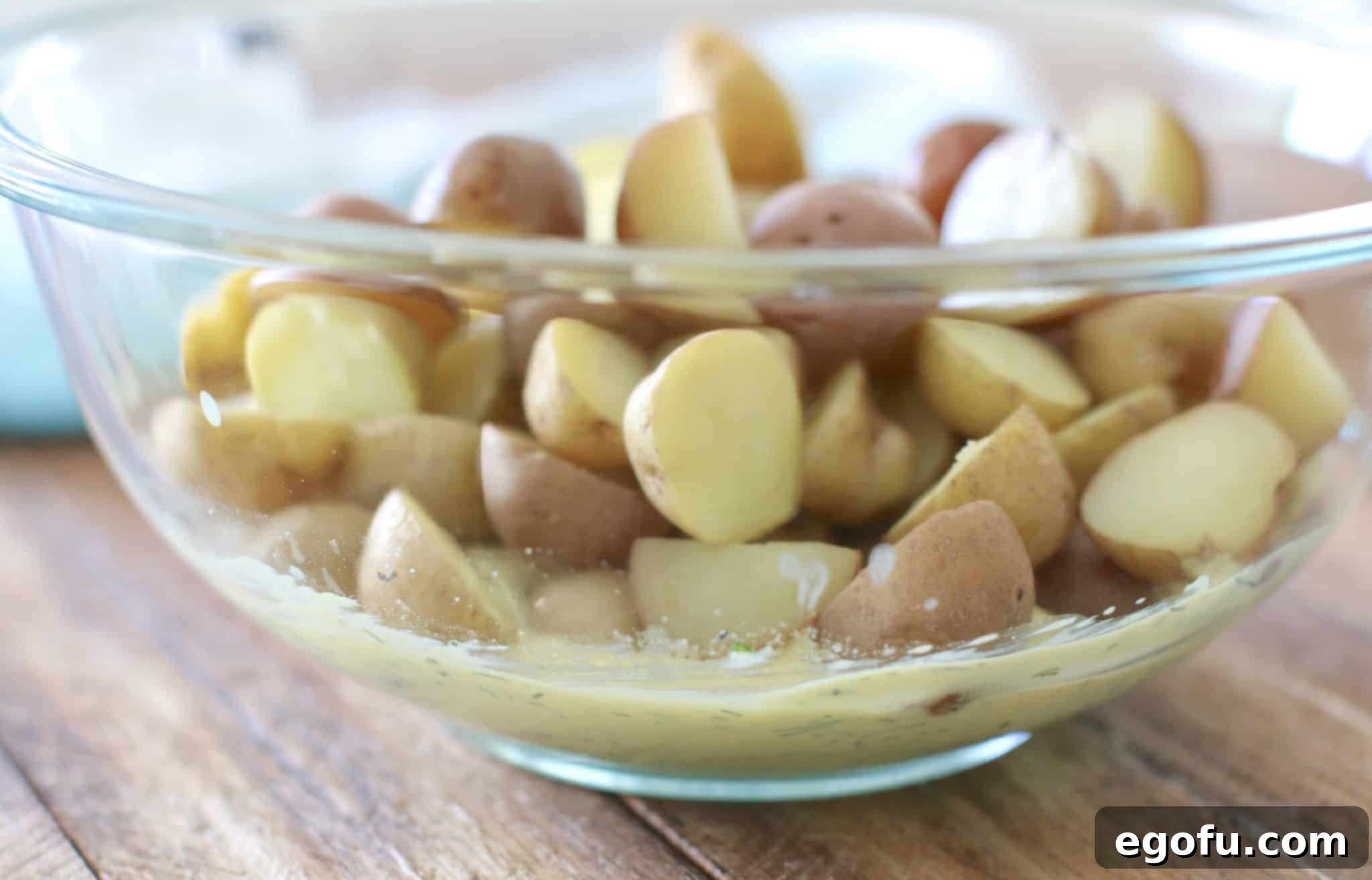 Warm potatoes being gently stirred with the dill dressing