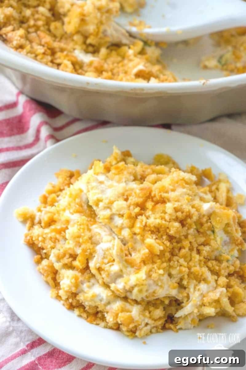 An easy Cracker Chicken Baked Casserole served on a white round plate, garnished with a sprig of fresh parsley.