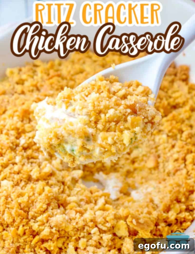 A white spoon is gently inserted into a rich, golden-brown Ritz Cracker Chicken Casserole, revealing its creamy chicken interior.