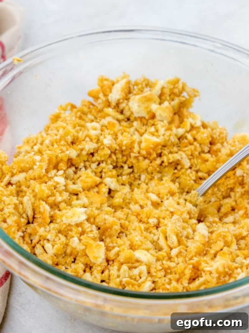 Crushed Ritz crackers are mixed with melted butter in a bowl, creating the iconic crunchy topping for the casserole.