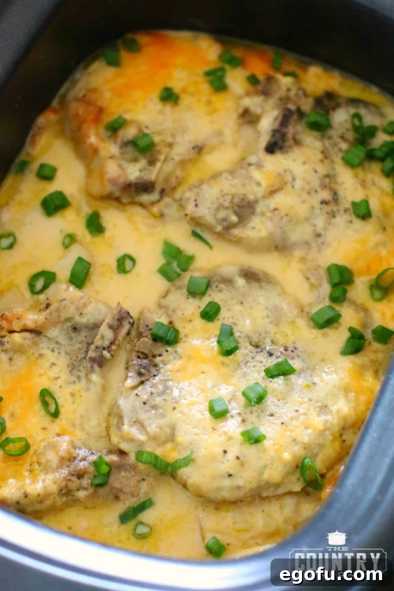 Crock Pot Smothered Pork Chops and Potatoes garnished with fresh green onions