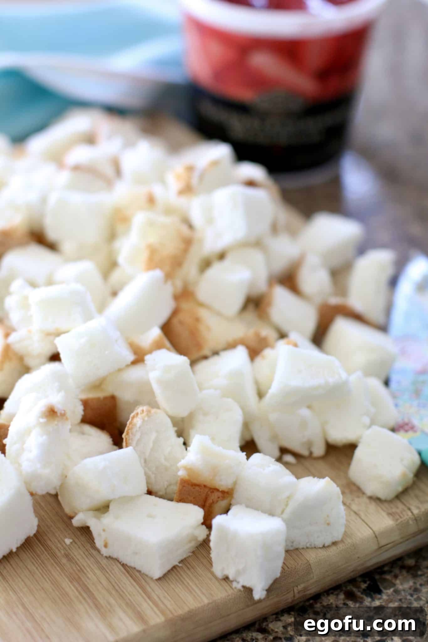 Strawberry Angel Delight 5 Diced angel food cake pieces neatly arranged on a cutting board, ready for assembly.