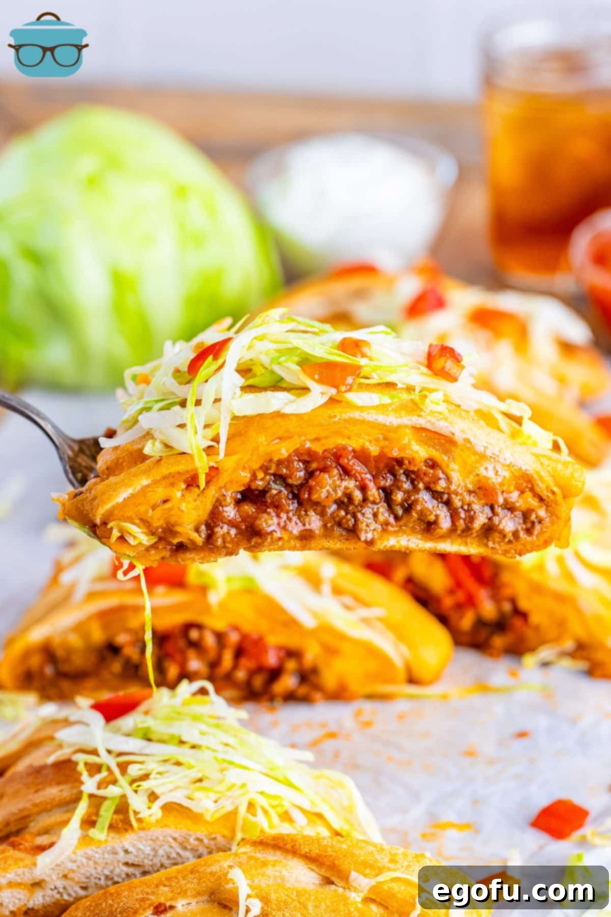 A serving utensil holding a slice of a Taco Braid, showcasing the delicious layers of filling.