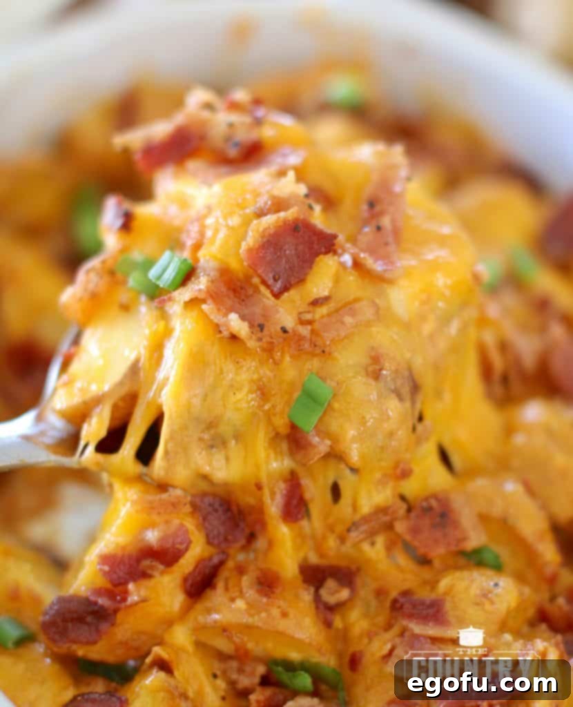 fully cooked Tex Mex Ranch Potatoes with a large silver spoon holding up a serving.