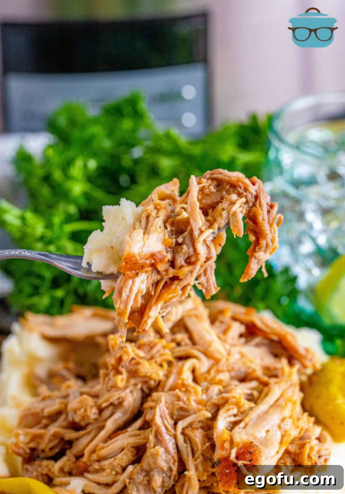 Fall-Apart Mississippi Pork Perfection 13 A fork holding up some mashed potatoes and shredded pork roast, showcasing a perfect bite.