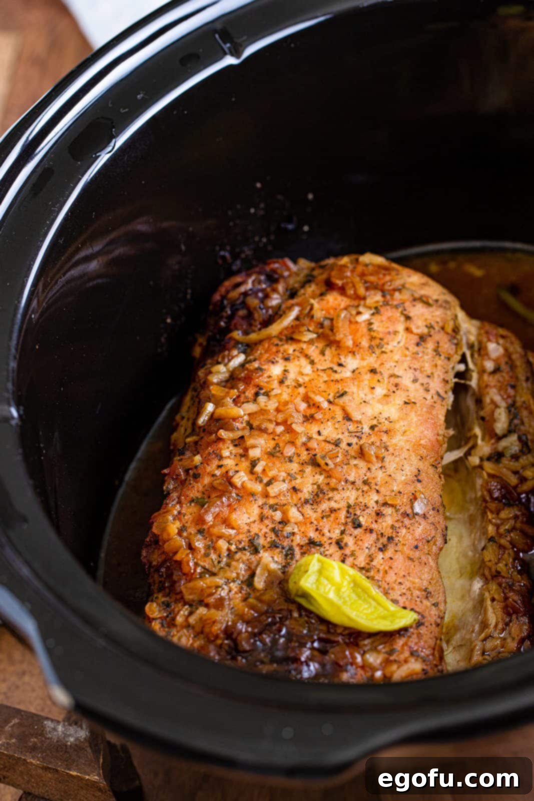 Fall-Apart Mississippi Pork Perfection 10 Fully cooked pork loin roast simmering in a slow cooker.