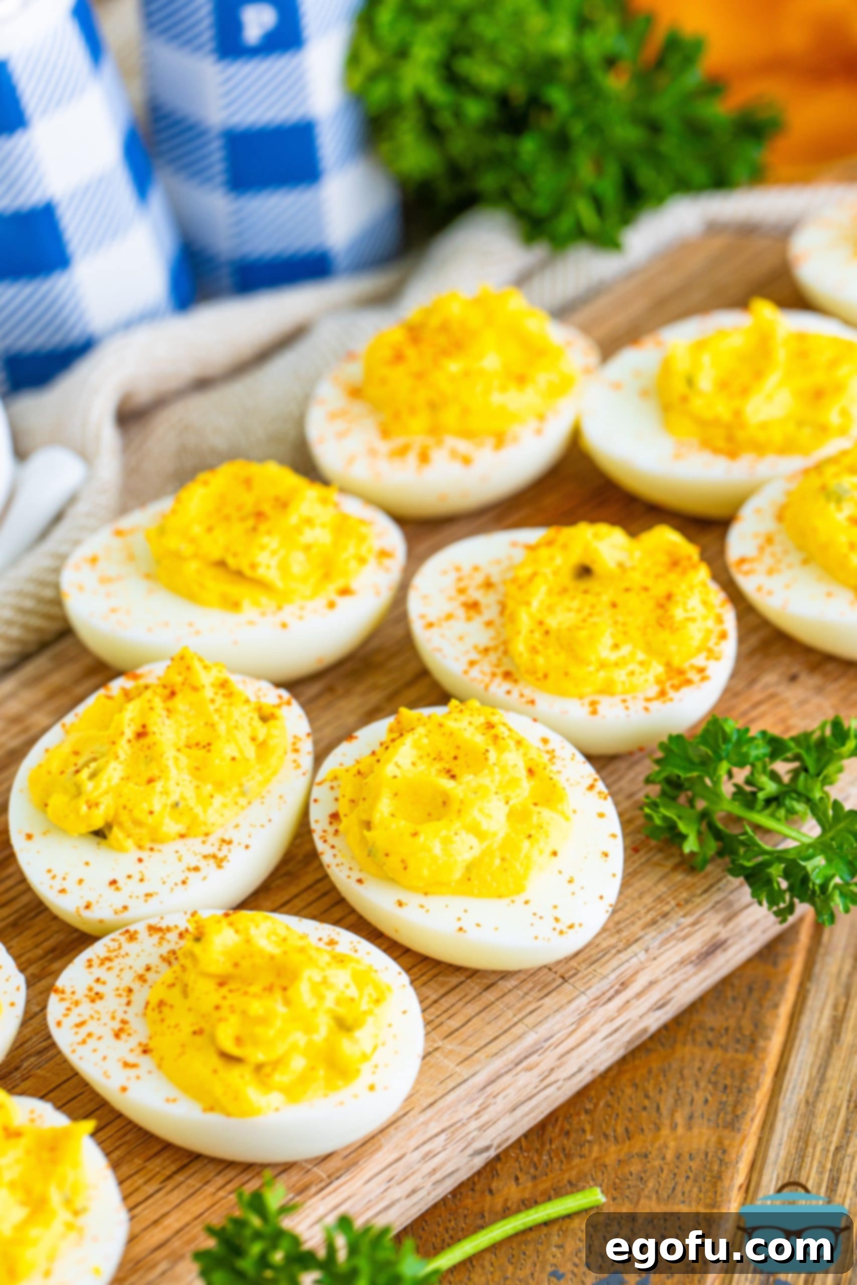 Classic deviled eggs elegantly arranged on a rustic wooden serving board, ready for a gathering.