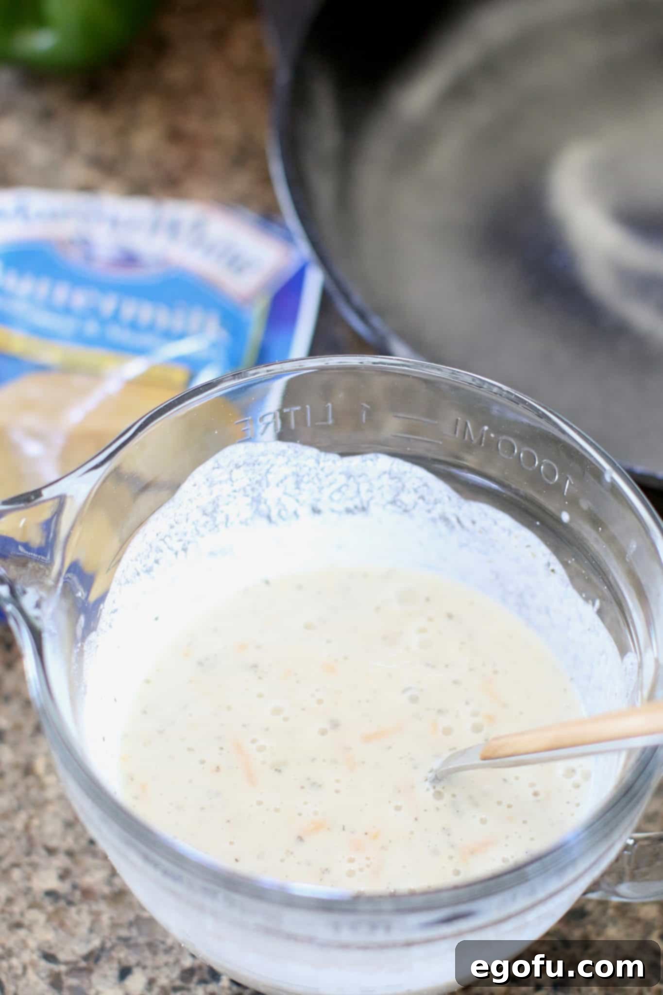 Golden Skillet Cornbread Pizza 5 cornbread batter and shredded cheese in a mixing bowl.