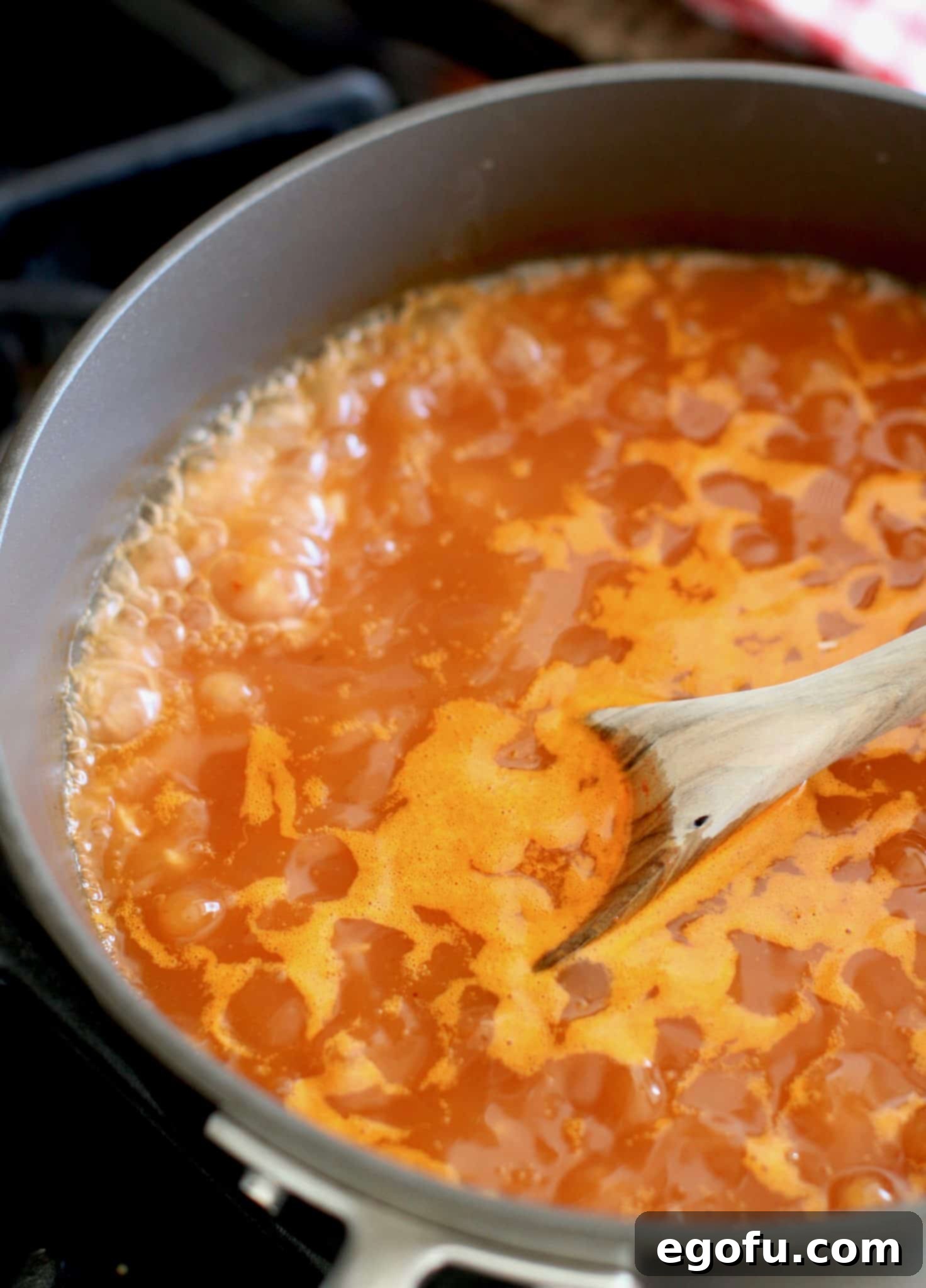 enchilada sauce mixture gently boiling in a skillet. 