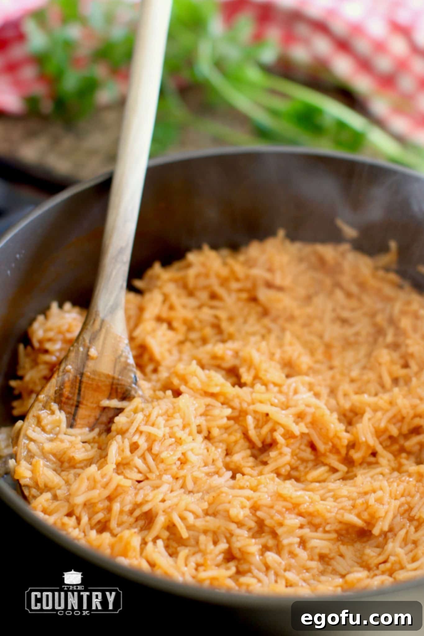 fully cooked rice in a large skillet with a wooden spoon.
