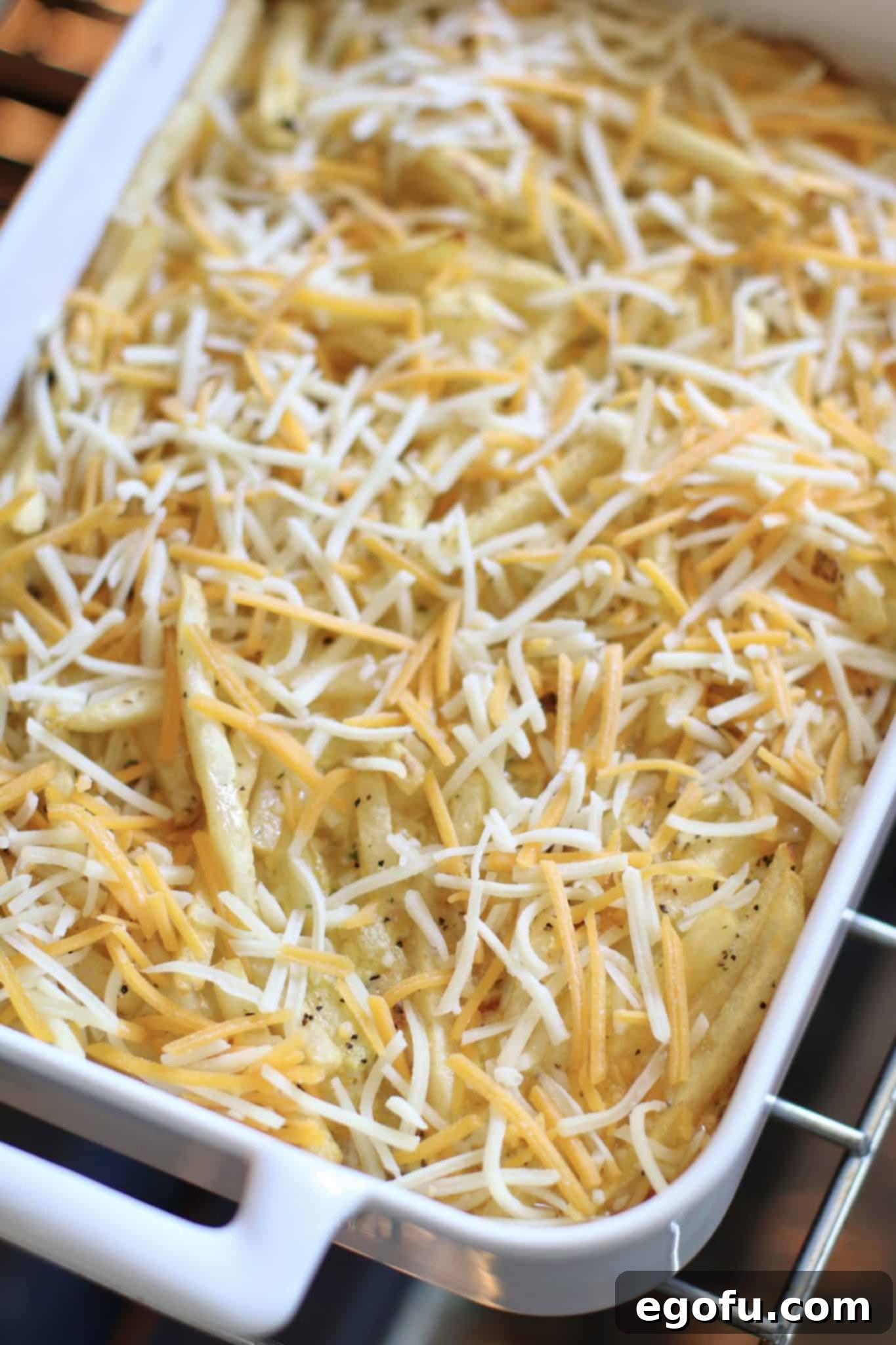 shredded cheese sprinkled onto cooked cheeseburger casserole.