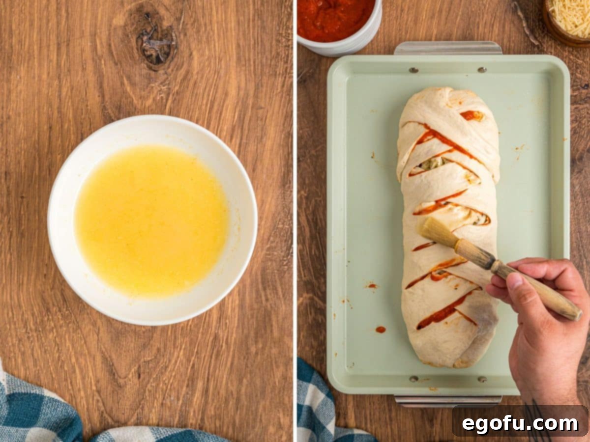 Melted butter being brushed on an unbaked stromboli.