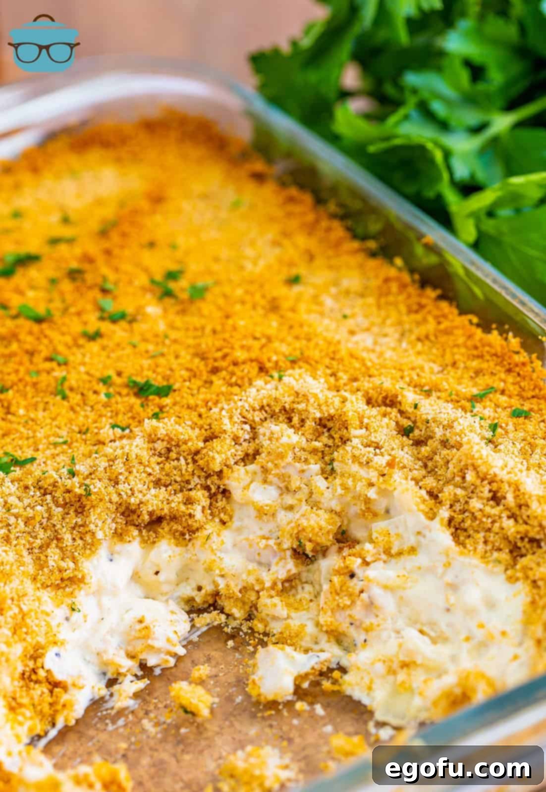 A close-up view of the chicken and rice casserole with a few servings already removed, revealing the creamy, textured interior.
