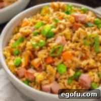 Golden Ham Fried Rice 8 Looking close up at a bowl of Ham Fried Rice, garnished with green onions, showcasing its inviting texture and colors.