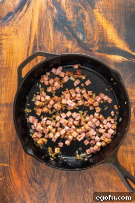 Golden Ham Fried Rice 9 Ham and onions in a skillet cooking, perfectly browning for maximum flavor in Ham Fried Rice.