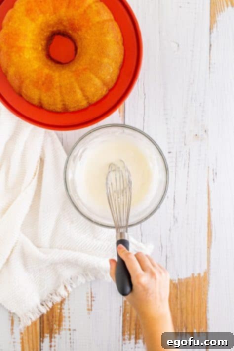 A whisk in a bowl of icing.