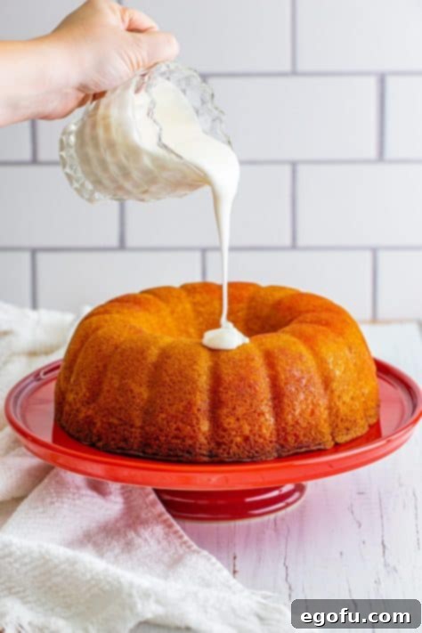 Icing being poured over a cake.