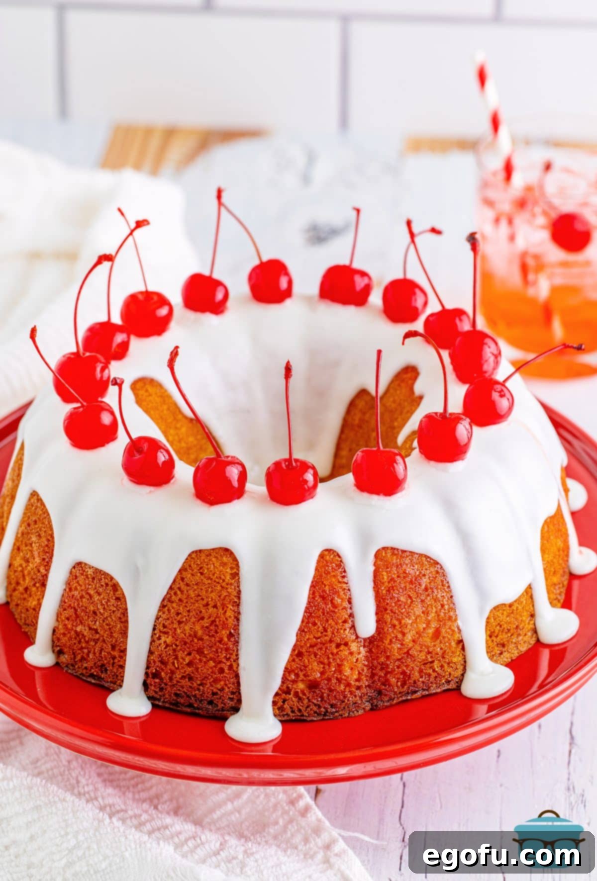 A beautifully frosted Shirley Temple Poke cake, garnished with bright red maraschino cherries, presented as a complete dessert.