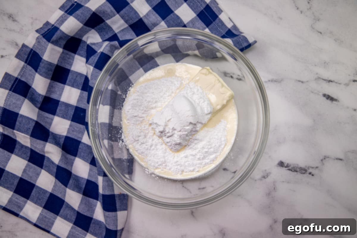Grandma B's Blueberry Icebox Bars 8 cream cheese and powdered sugar in a clear bowl.