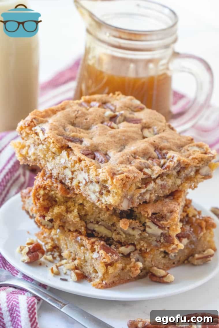 Southern Pecan Cake Bars, stacked on a white plate with a jar of caramel sauce in the background.