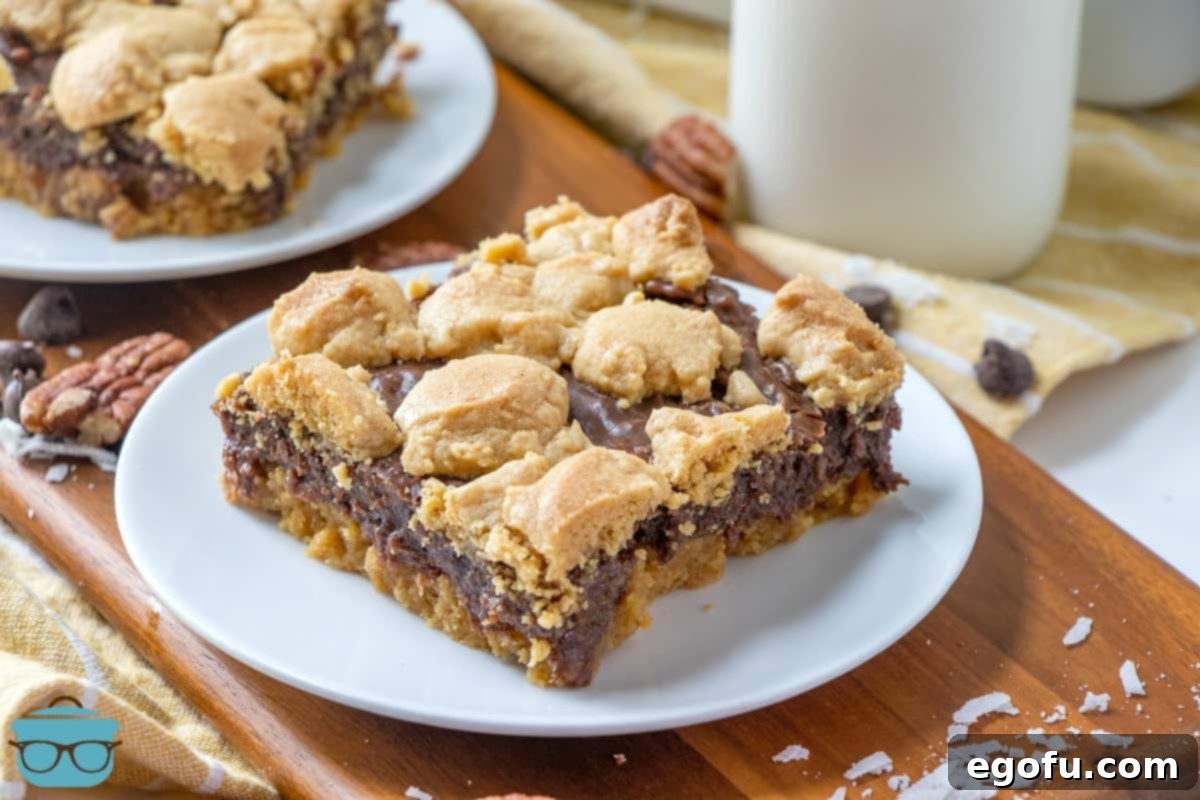 Fudge-filled peanut bars, slice on a white plate with a jar of milk in the background.