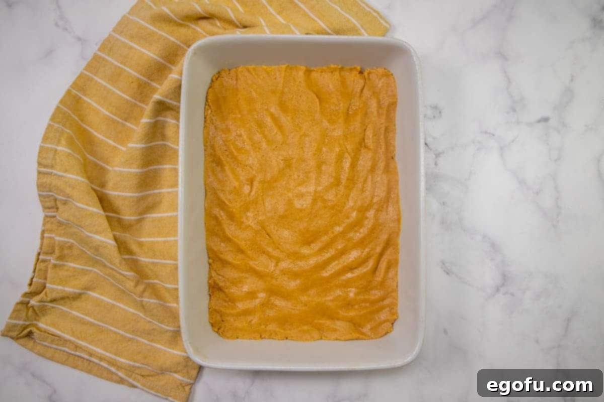 dough spread out into a 9x13-inch white baking dish. 