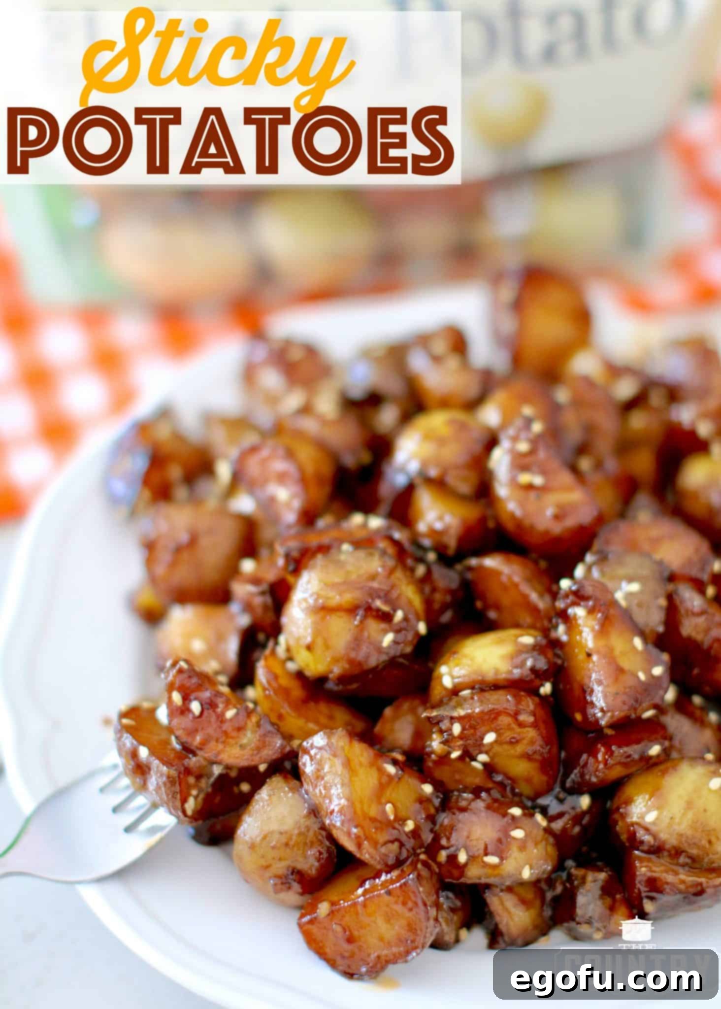 Sticky Potatoes shown on a white plate with a fork inserted into one of the potatoes.