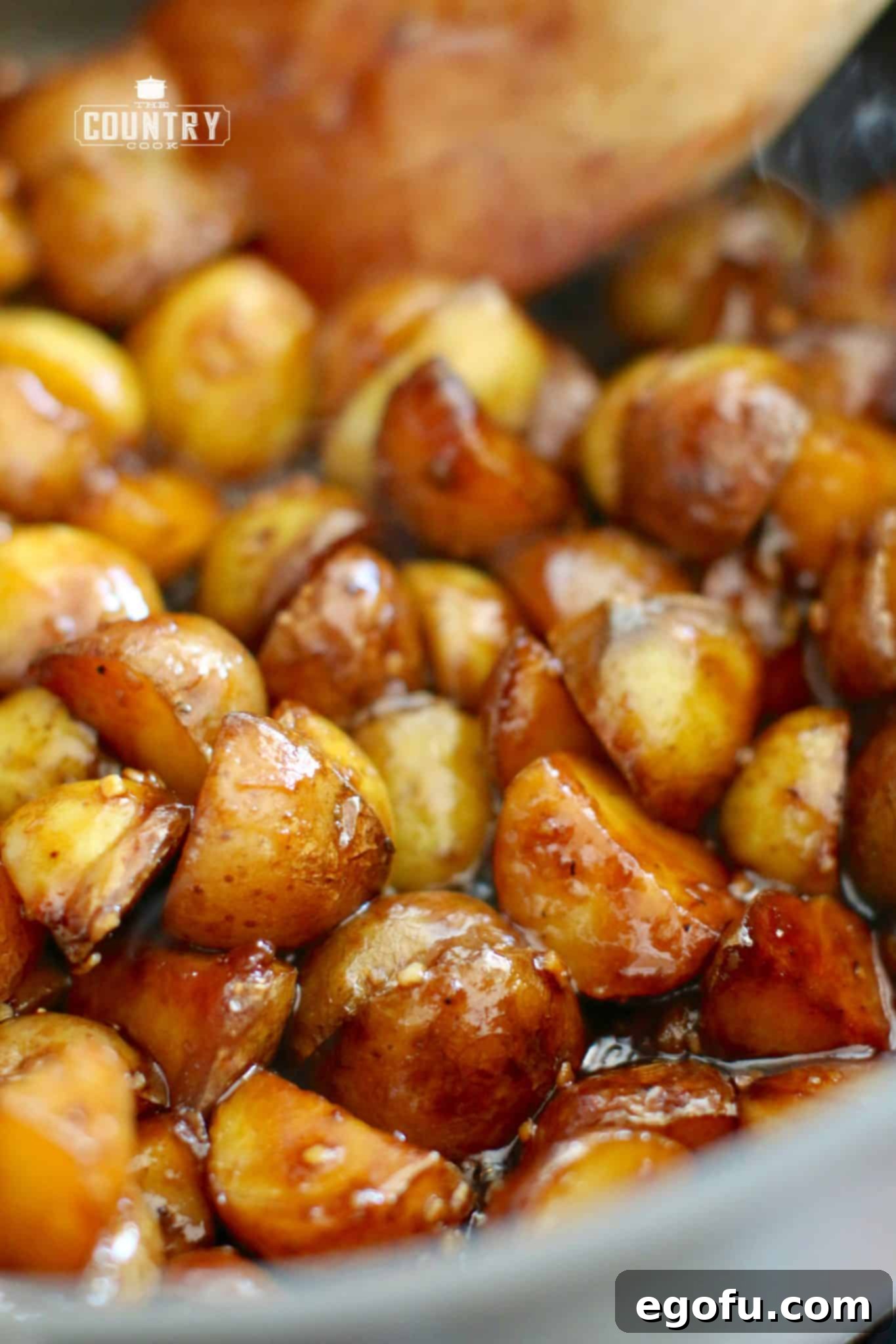 fully cooked sticky potatoes shown close up in a skillet.