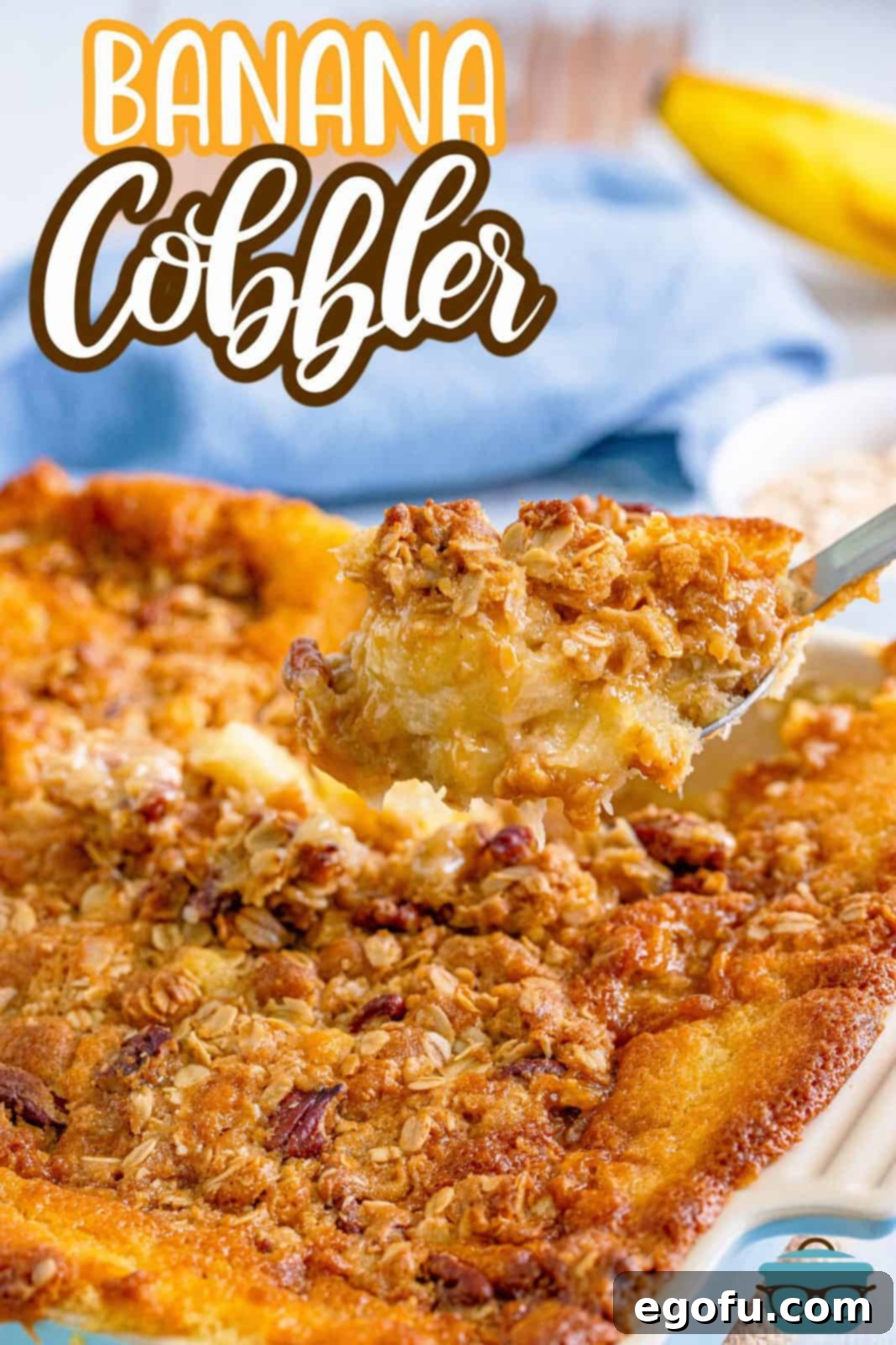 A large serving spoon scooping out a generous portion of warm, bubbling Southern Banana Cobbler from a rustic baking dish, highlighting the gooey banana filling and the crumbly pecan streusel.