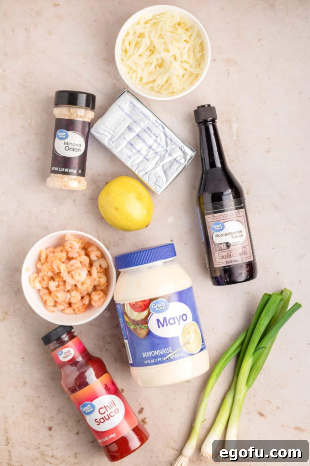 A vibrant flat lay showcasing all the fresh and canned ingredients needed for making Shrimp Dip, including green onions, shrimp, lemon, mayo, chili sauce, cream cheese, Worcestershire sauce, mozzarella cheese, and minced onion.