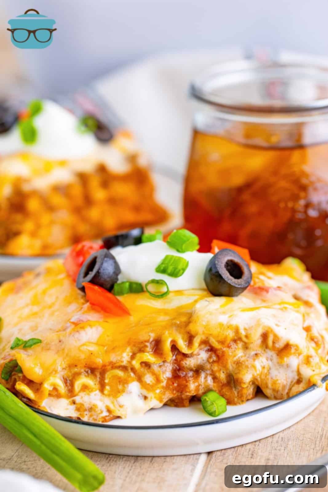 A perfectly portioned slice of Mexican Lasagna on a round white plate, showcasing its vibrant layers.