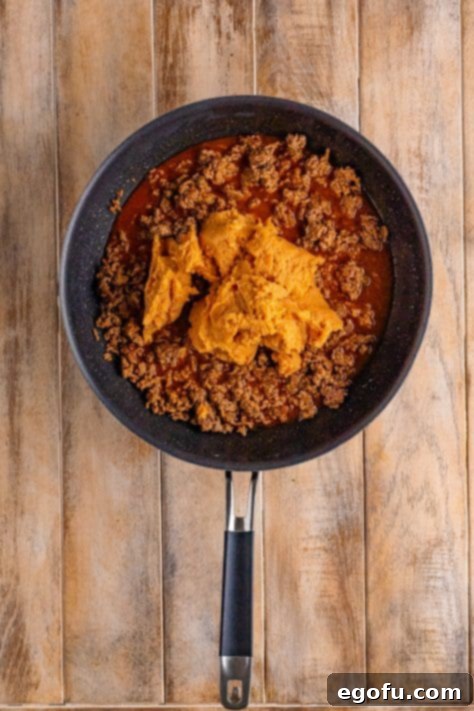 refried beans added to taco seasoned ground beef.
