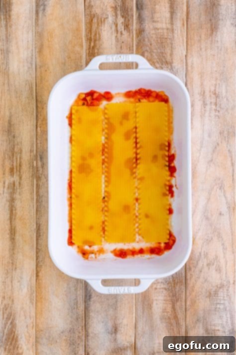 three lasagna noodles layered into the baking dish.