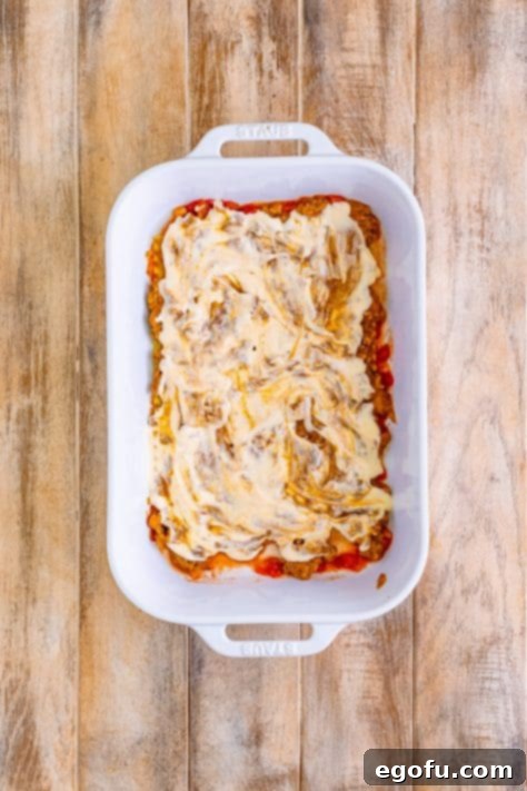 Alfredo sauce spread on top of ground beef mixture.