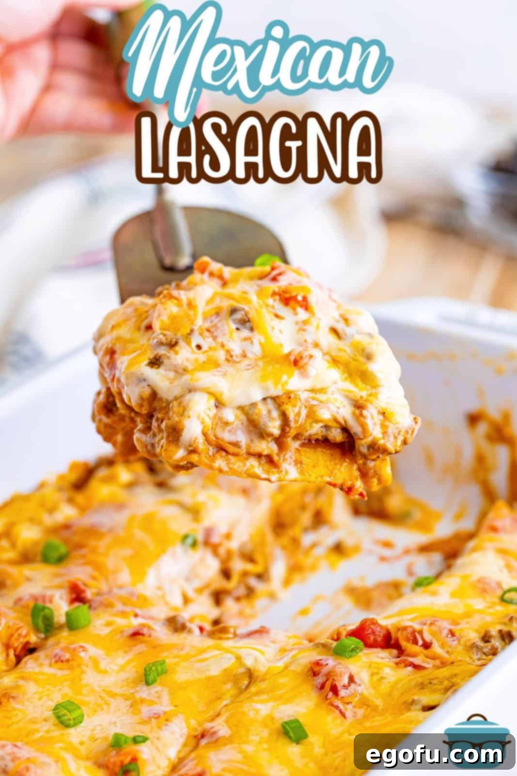A spatula lifting a perfect slice of Mexican Lasagna from the baking dish, showing off its rich, layered interior.