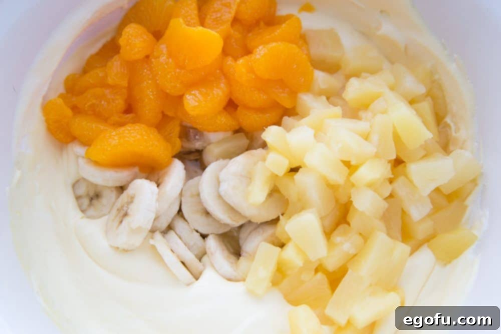 A large mixing bowl containing the creamsicle fruit salad mixture, ready for chilling.