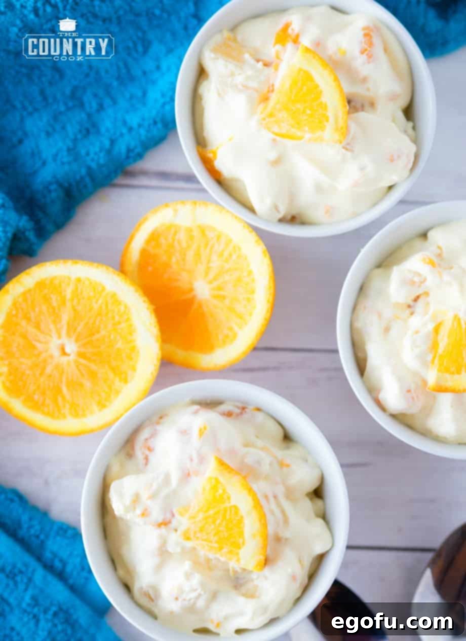 Individual serving bowls filled with bright and creamy orange creamsicle fruit salad, ready to enjoy.