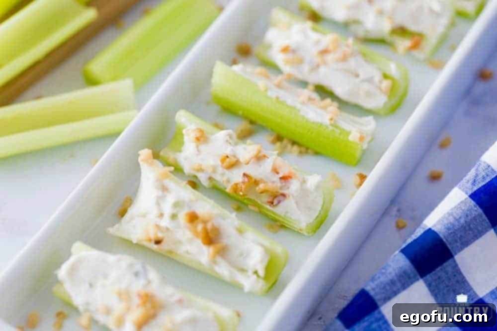 Tray of celery stuffed with cream cheese, vegetable soup mix, and topped with walnuts. A perfect party appetizer.
