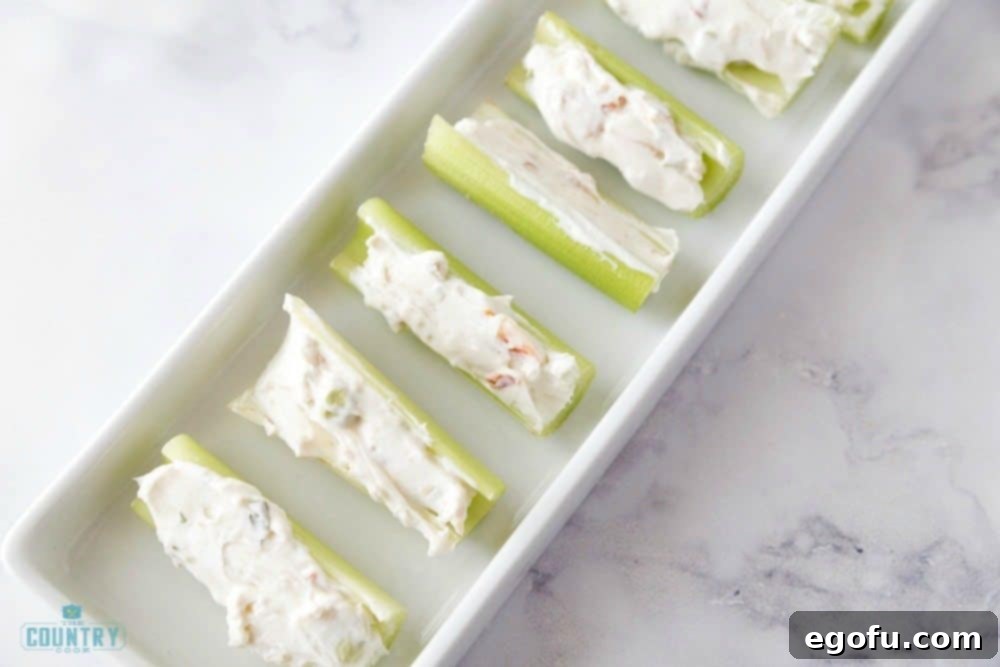 Celery pieces stuffed with cream cheese mixture, arranged on a white platter.
