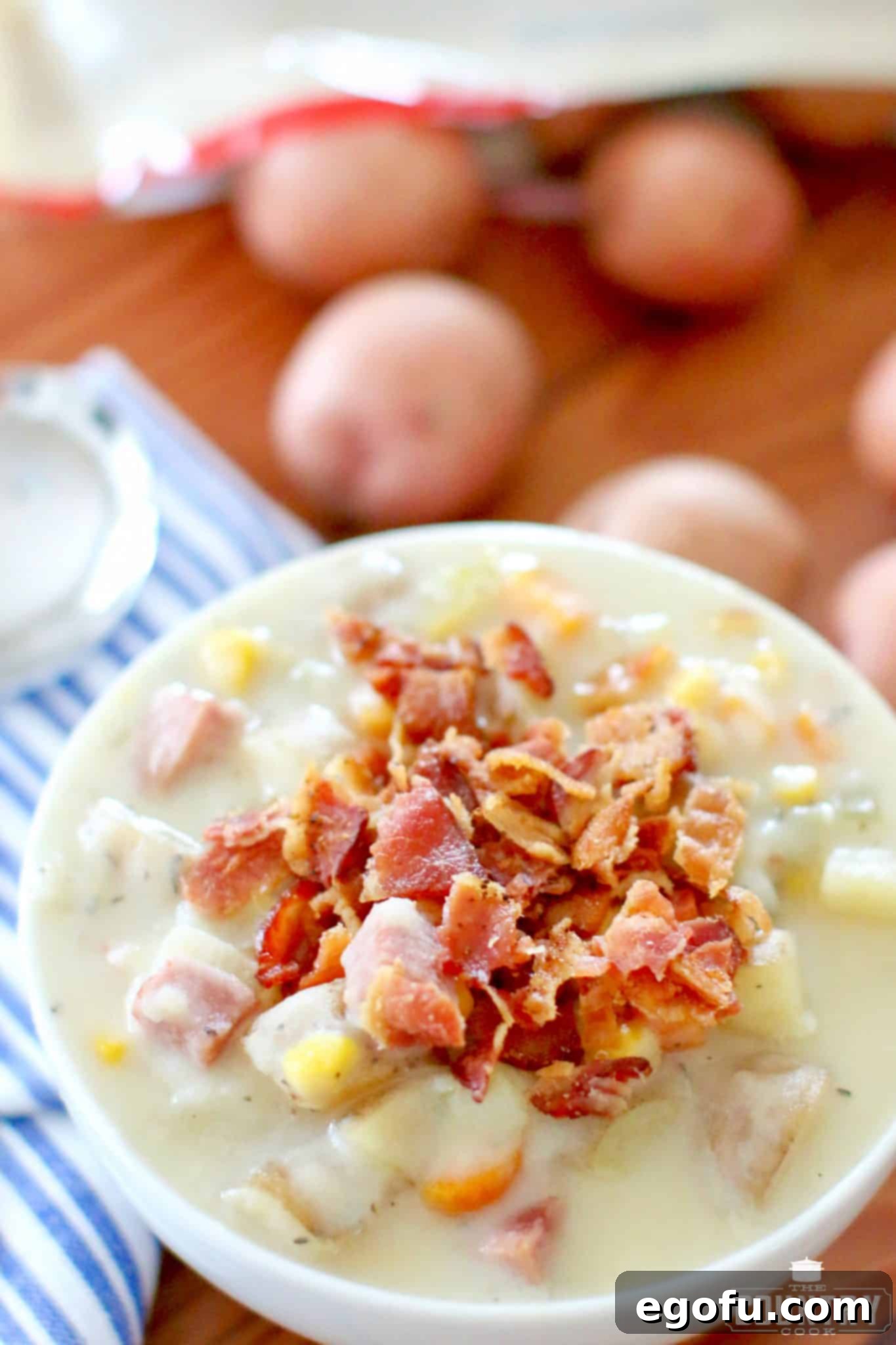 Crumbled bacon on ham, potato and corn chowder in a bowl.