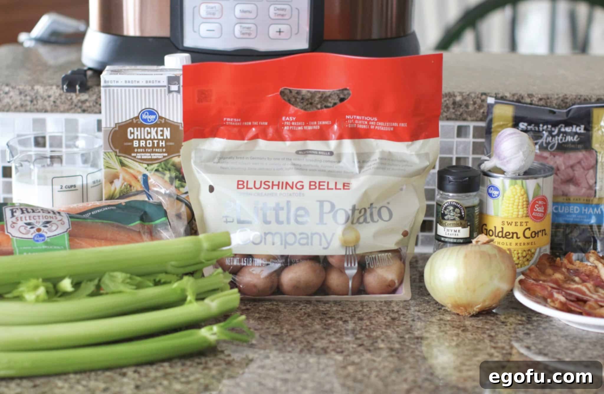 ingredients pictured for potato chowder: red potatoes, onion, carrots, celery, garlic, dried thyme, ham, corn, chicken broth and milk.
